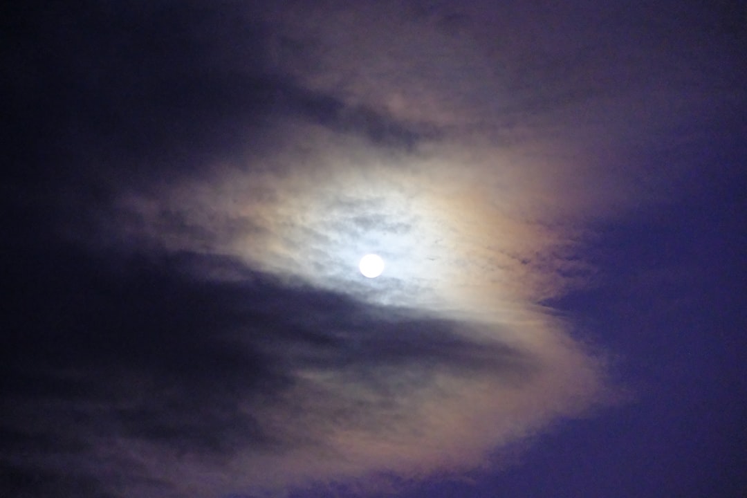 A full moon in a cloudy sky with clouds