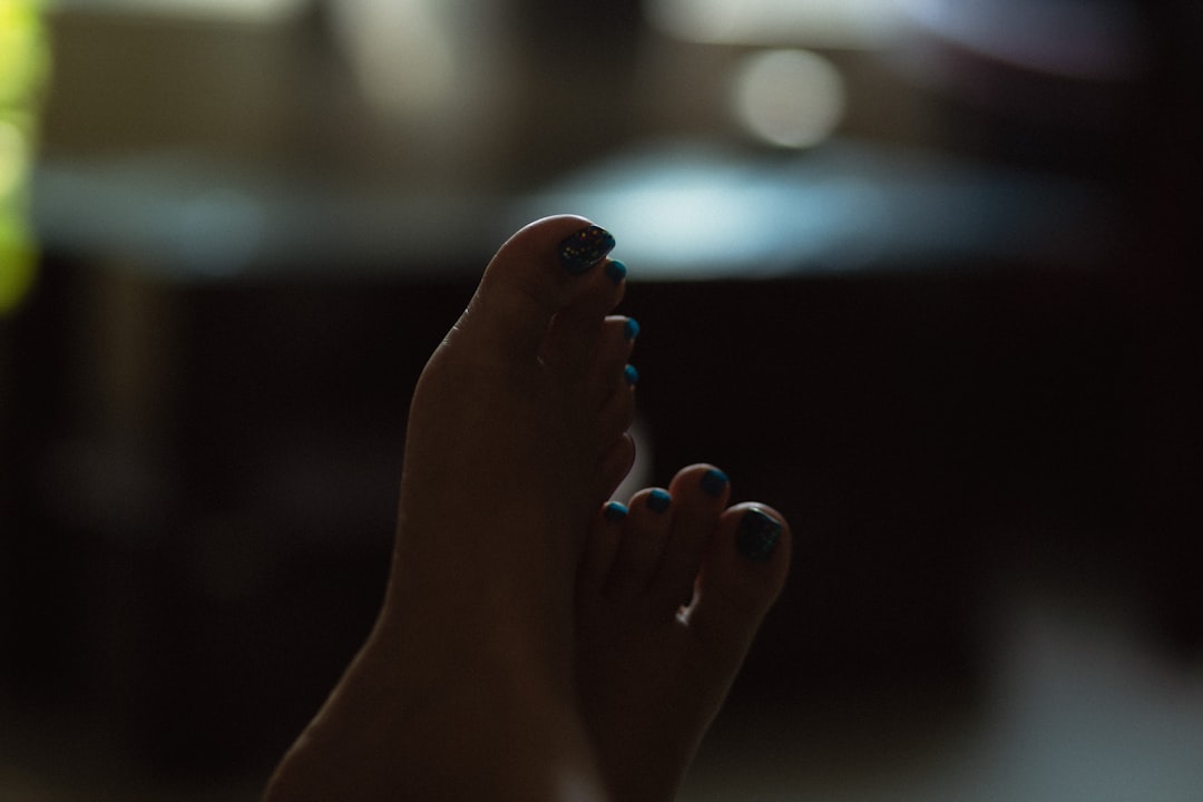 Close up of a woman's painted toenails in shadow