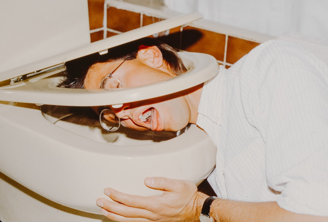 Man with head in toilet bowl