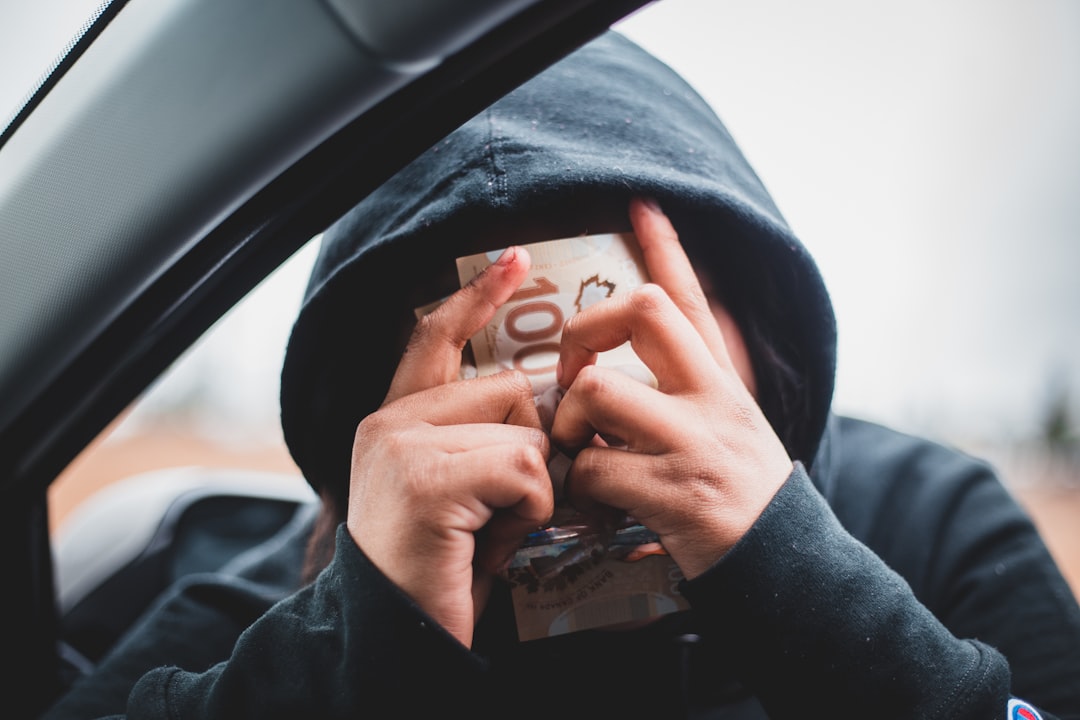 a person in a hoodie holding a book in their hands