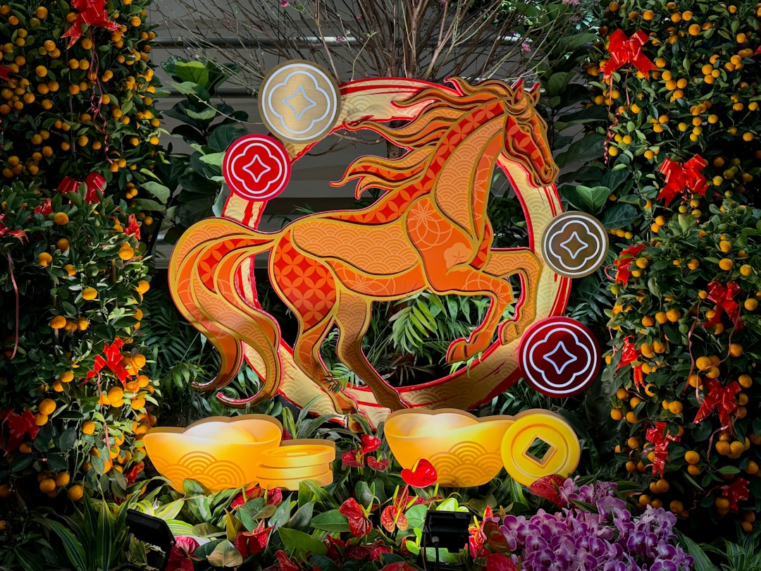 Golden horse sculpture surrounded by festive decorations and gold ingots.