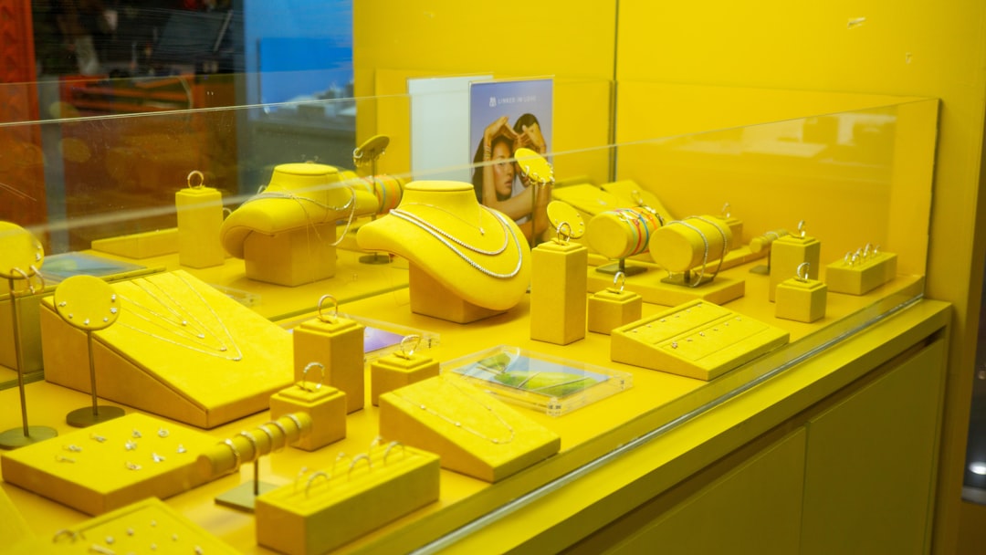 Yellow jewelry displayed in a brightly lit store window.